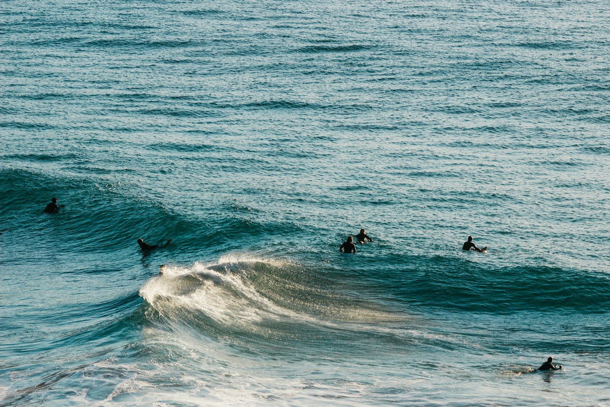 Group of surfers waiting for a set in the line-up at Llandudno Beach, Cape Town