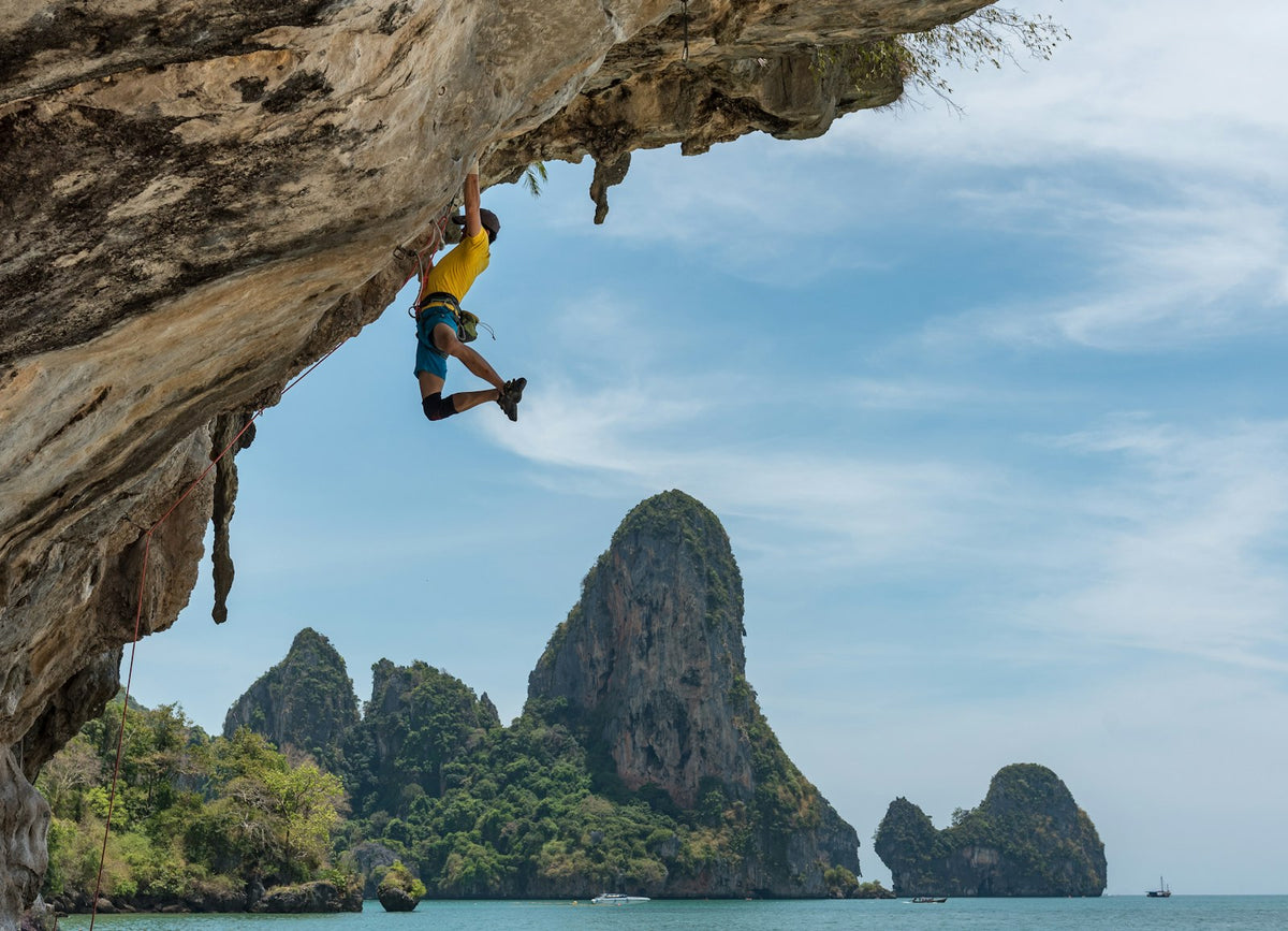 Climber on a cliff beside a beach