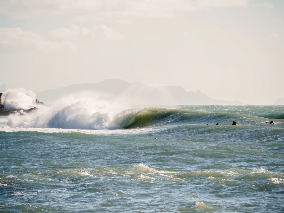 A group of people riding surfboards on a wave in Marseille, France