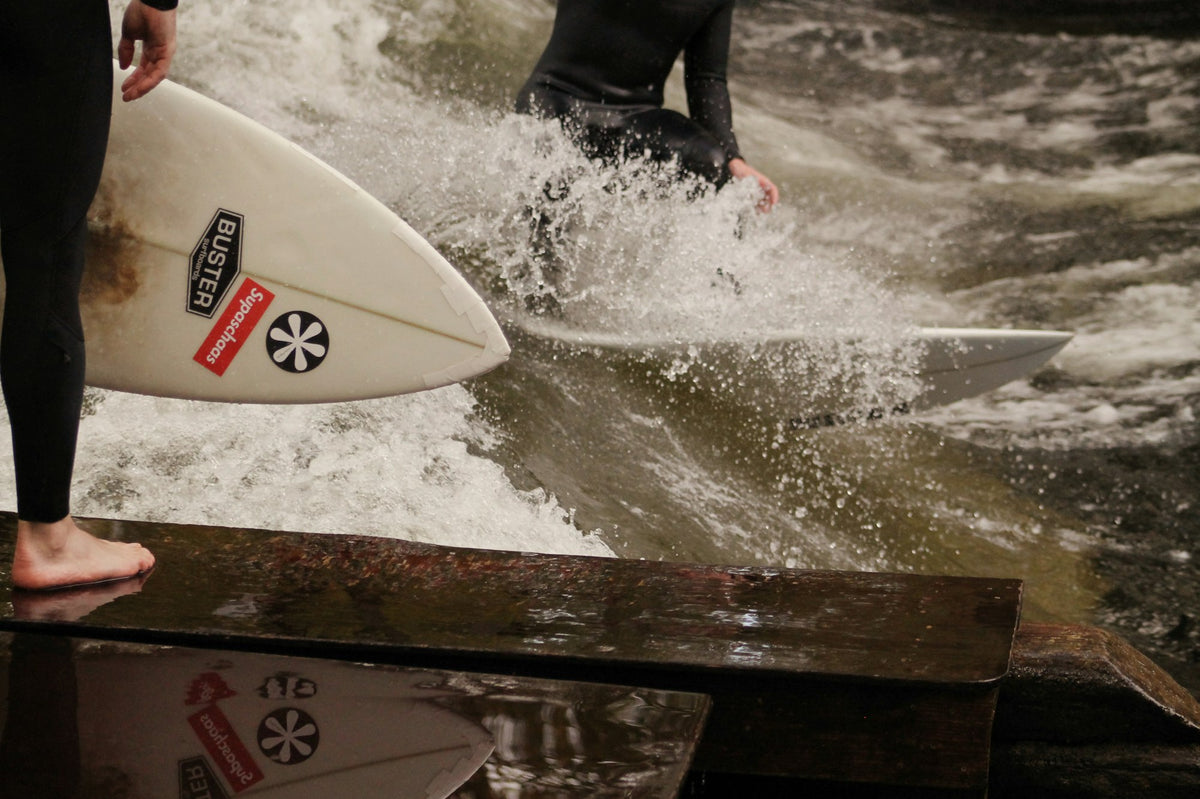 Surfer in a full wetsuit holding a surfboard