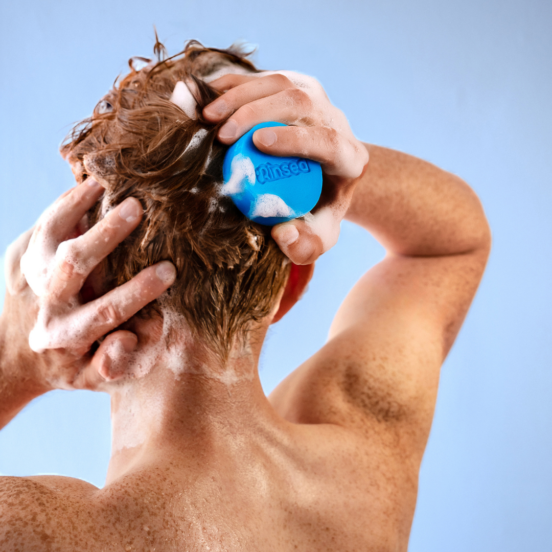 Man washing his hair with a blue Minty Cactus 3-in-1 bar, seen from behind