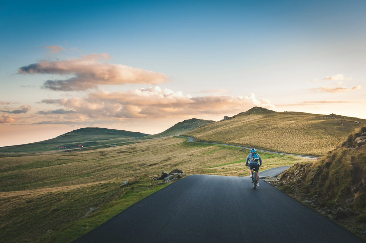 Cyclist on a road with a mountain in the distance