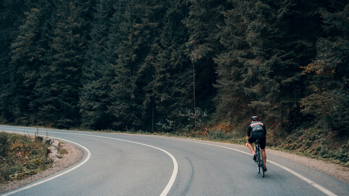 Cyclist on a winding forest road
