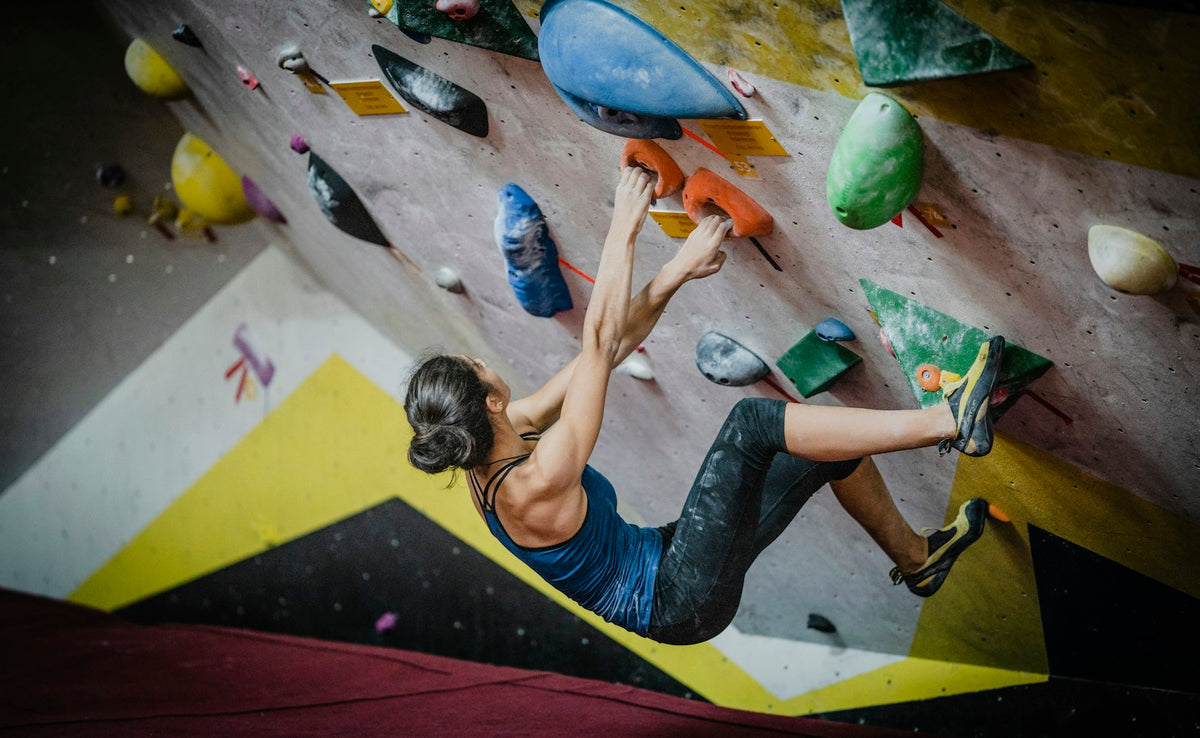 Woman climbing inside a climbing gym