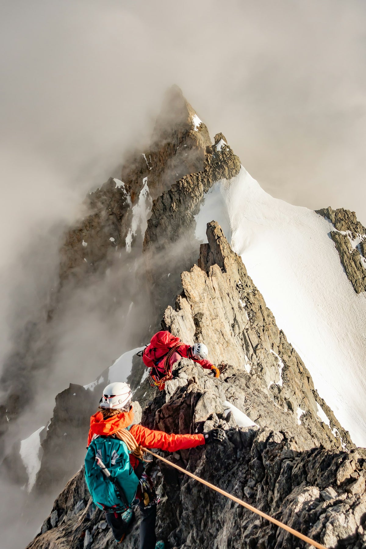 Two mountaineers on a rocky, snowy ridge