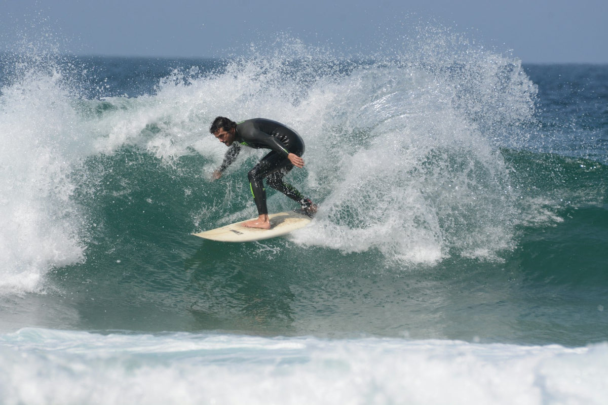Surfer in wetsuit op een golf bij Praia do Tonel, Sagres, in de Algarve