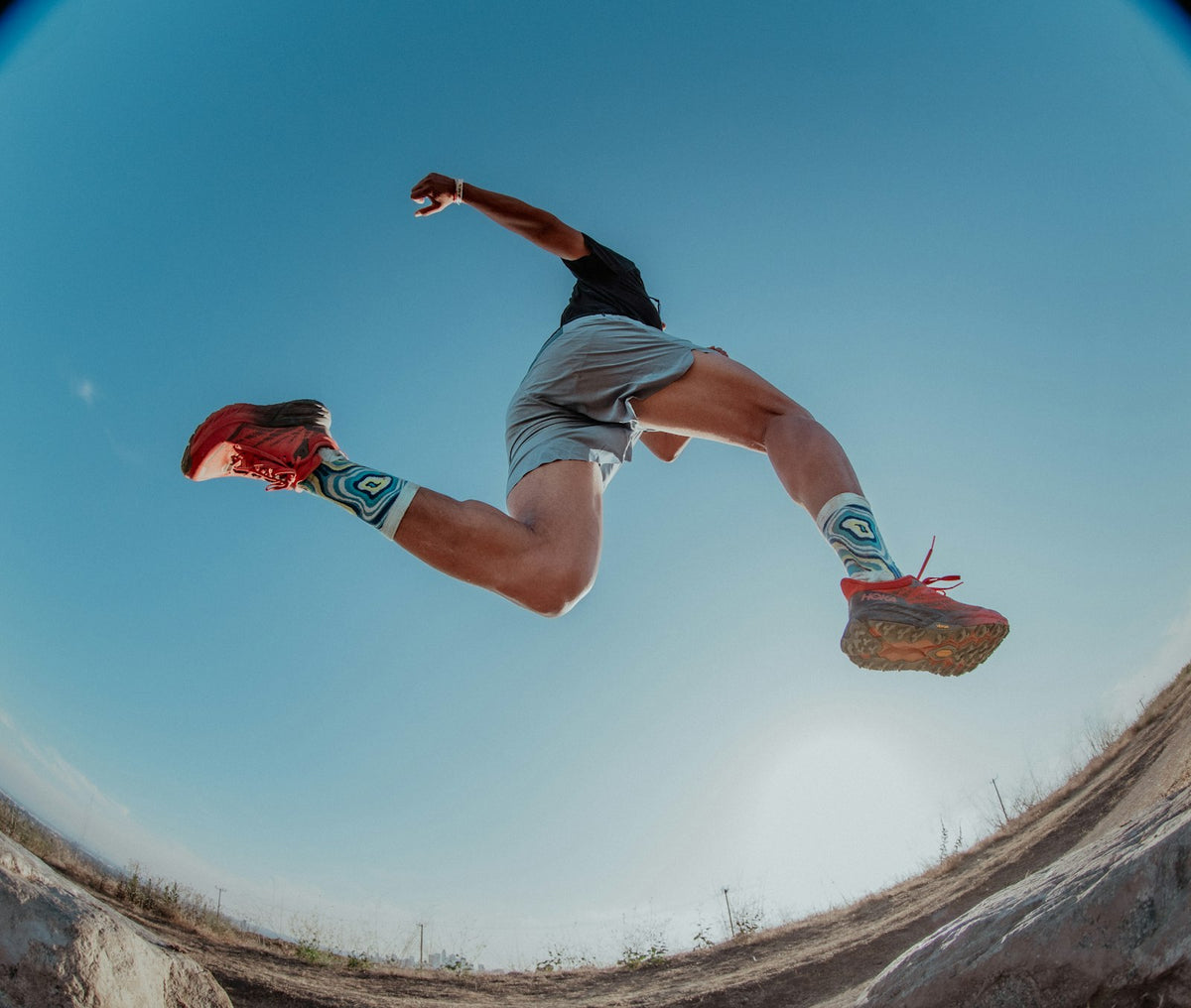 Trail runner leaping on a mountain path