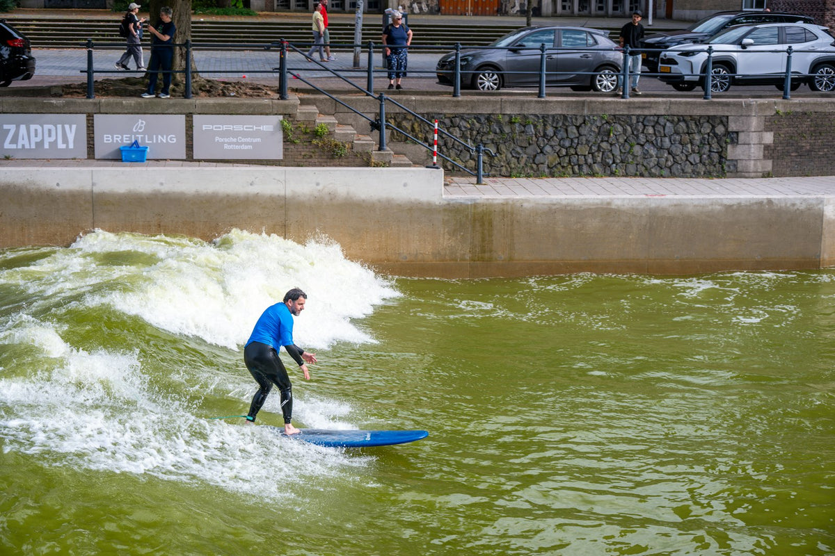 Surfer op een kunstmatige golf in het centrum van Rotterdam, Nederland