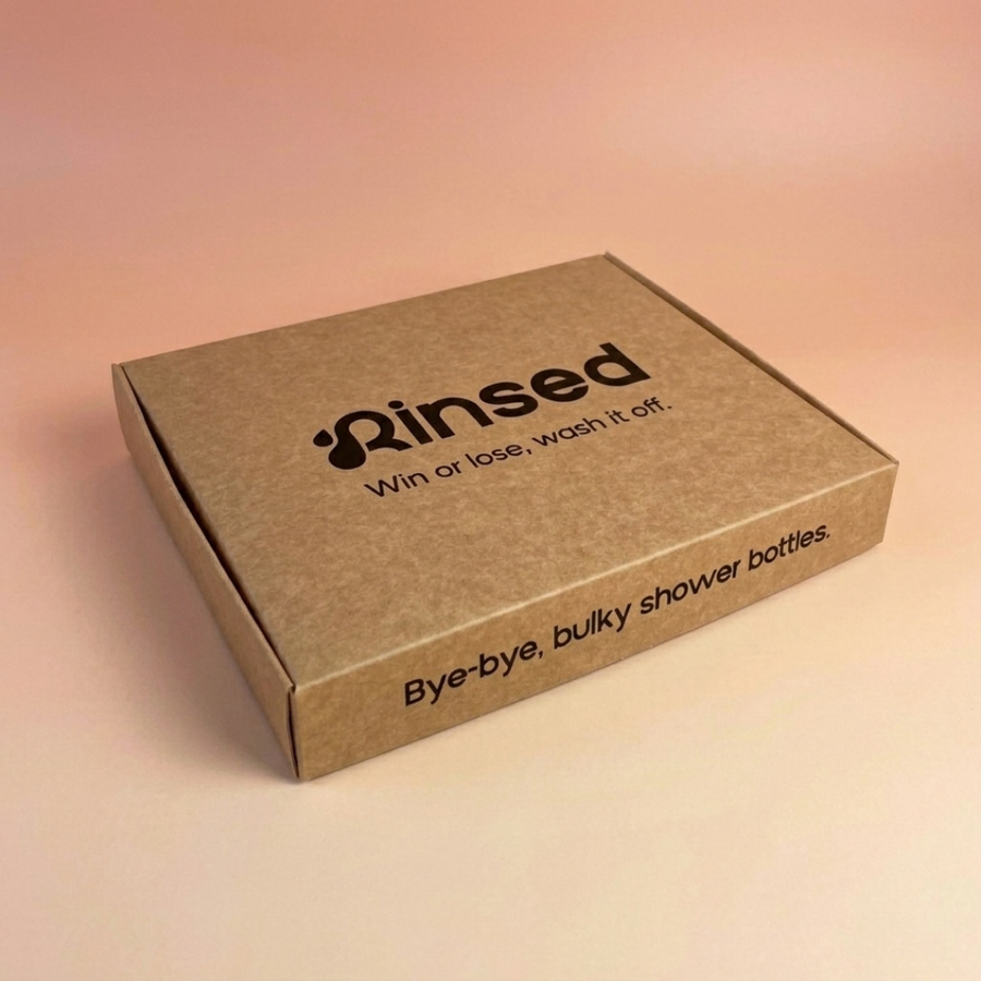 Rinsed™ gift box seen from the side, reading Bye-bye, bulky shower bottles, on a pink background